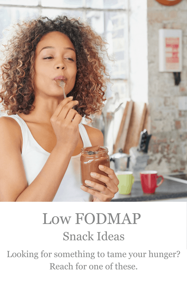 Woman eating peanut butter out of jar with text overlay: Low FODMAP Snack Ideas