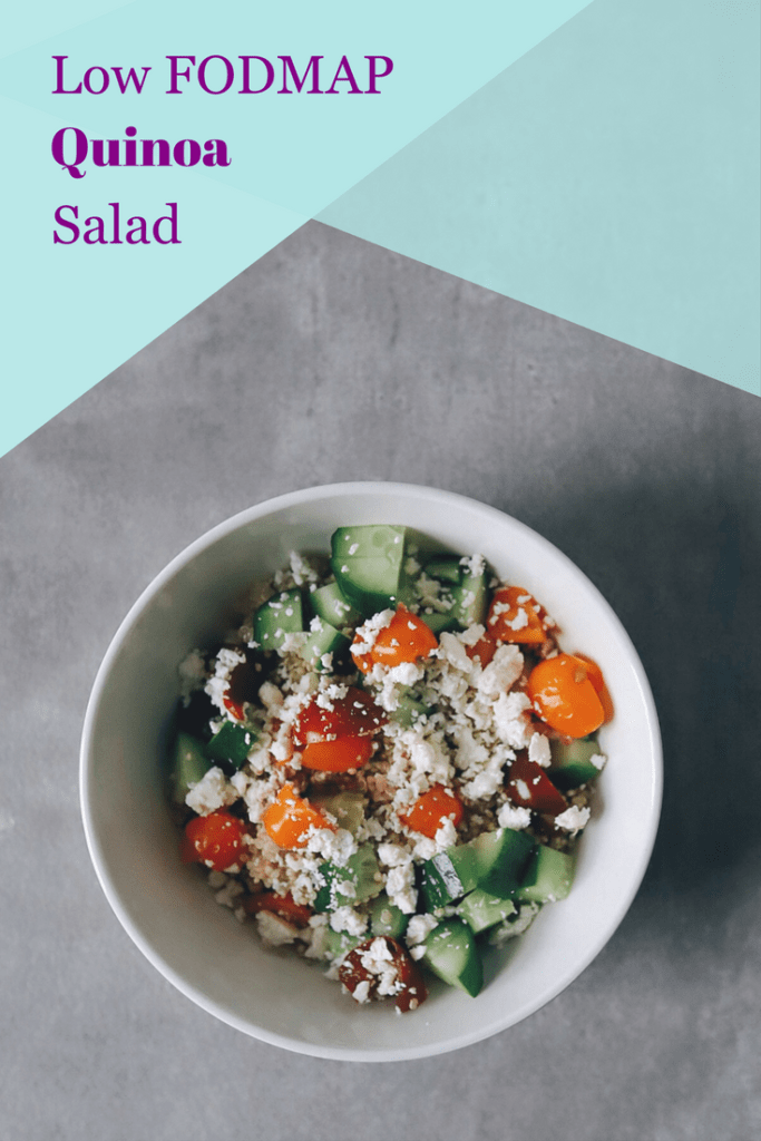 Quinoa salad topped with tomato, cucumber, and feta cheese with text overlay: Low FODMAP quinoa salad