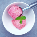 two scoops of low FODMAP mint berry frozen yogurt in bowl with ice cream scoop