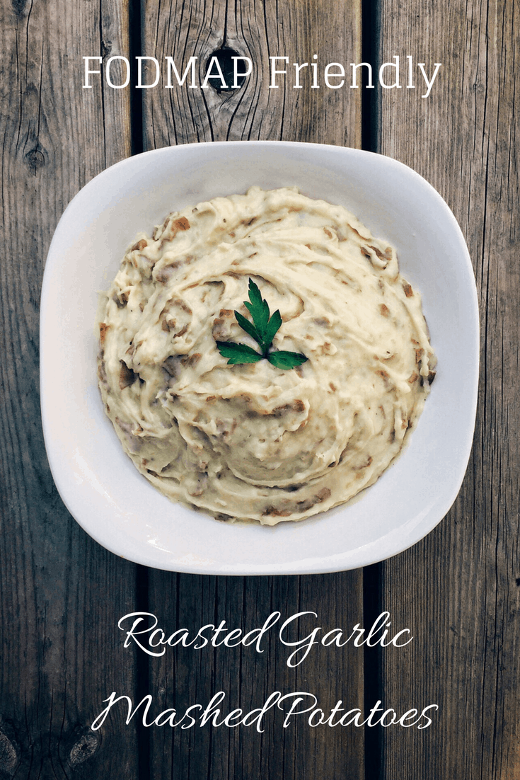 low fodmap roasted garlic mashed potatoes in serving dish with text overlay: Fodmap friendly roasted garlic mashed potatoes