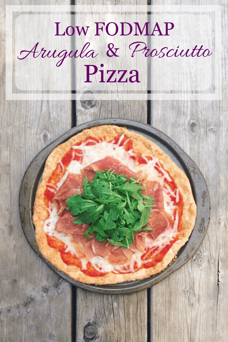 Low FODMAP Arugula and Prosciutto Pizza in pizza pan with text overlay: Low FODMAP Arugula and Prosciutto Pizza