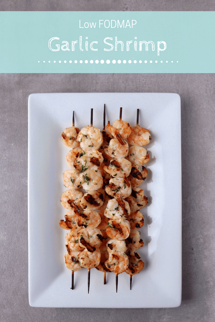 Low FODMAP Garlic Shrimp skewers on plate with text overlay