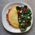 Low FODMAP Bruschetta Omelet on plate with side salad