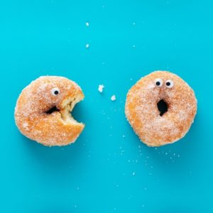 Doughnut on left trying to eat doughnut on right