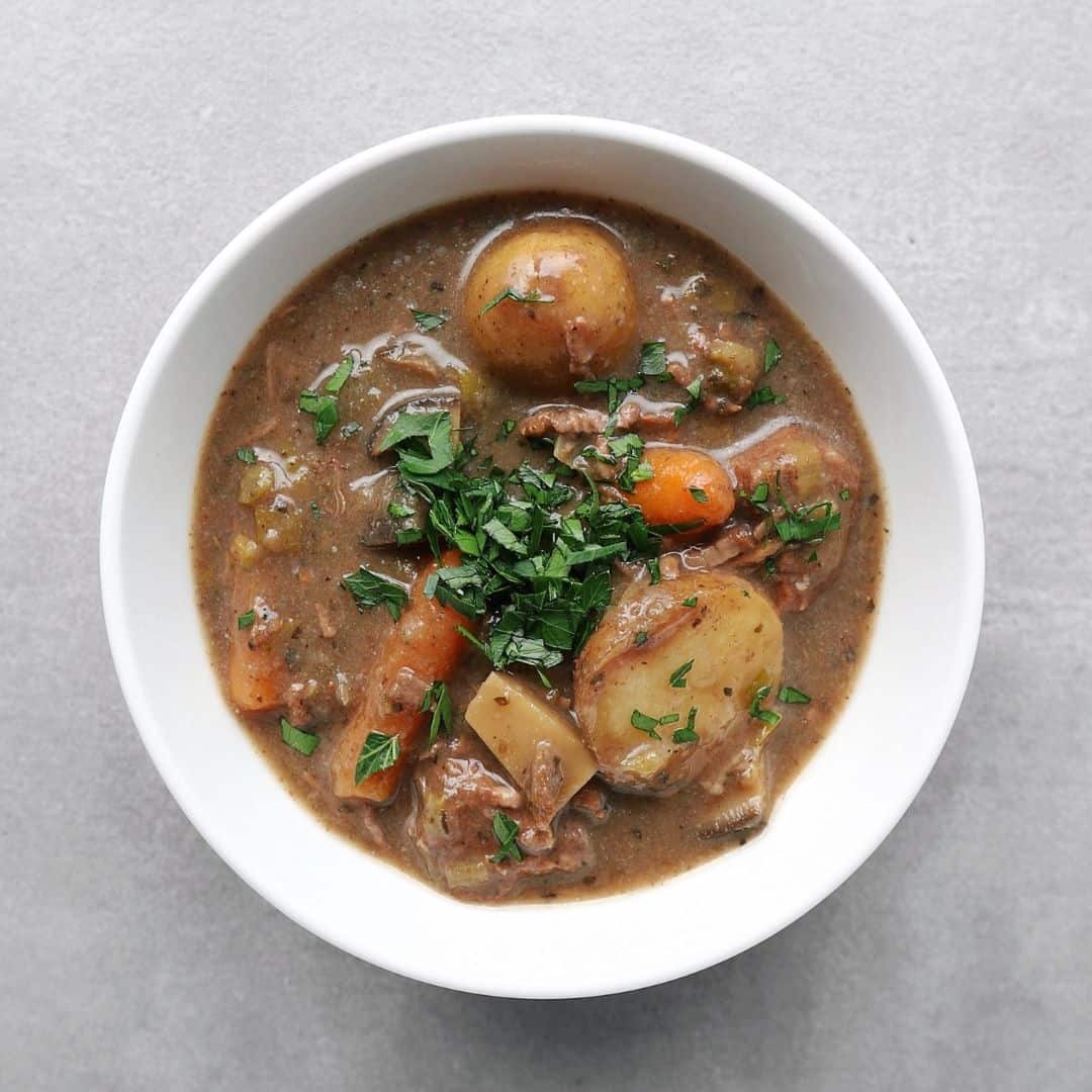 Low FODMAP beef stew in bowl on grey background