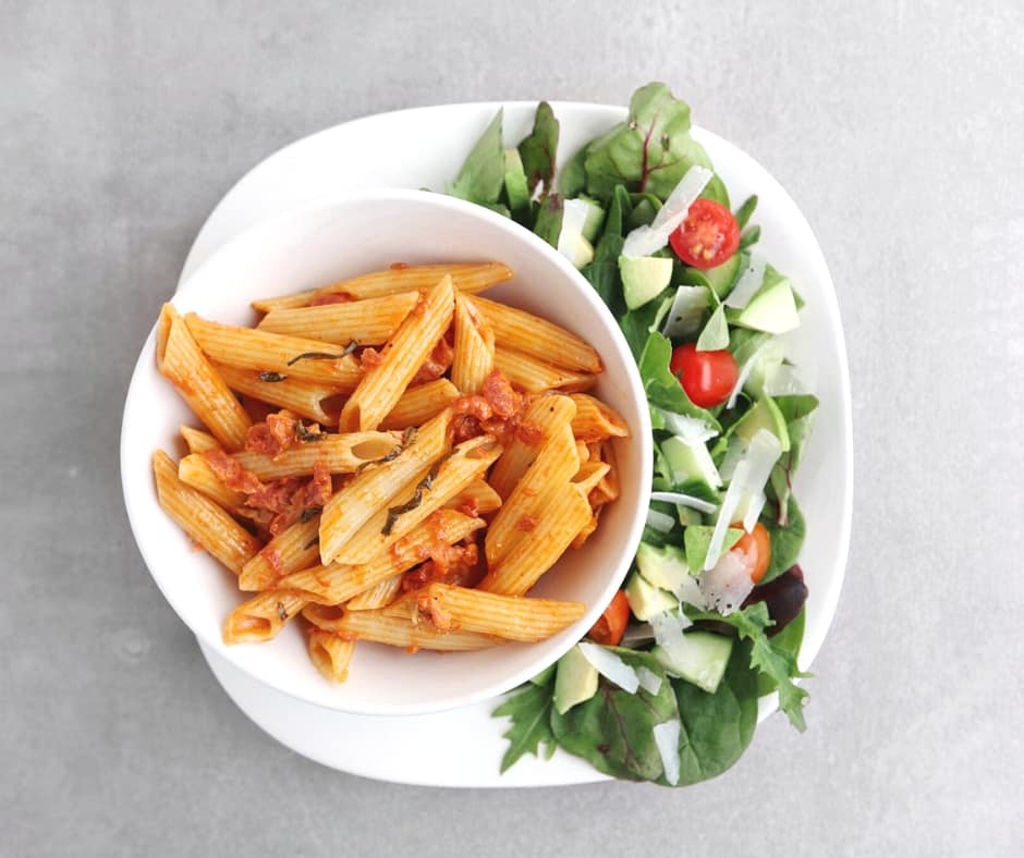 Low FODMAP penne alla vodka on plate with side salad - 940 x 788