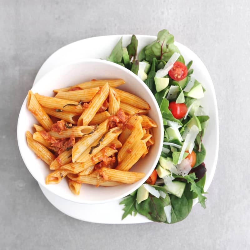 Low FODMAP penne alla vodka on plate with side salad - 800 x 800