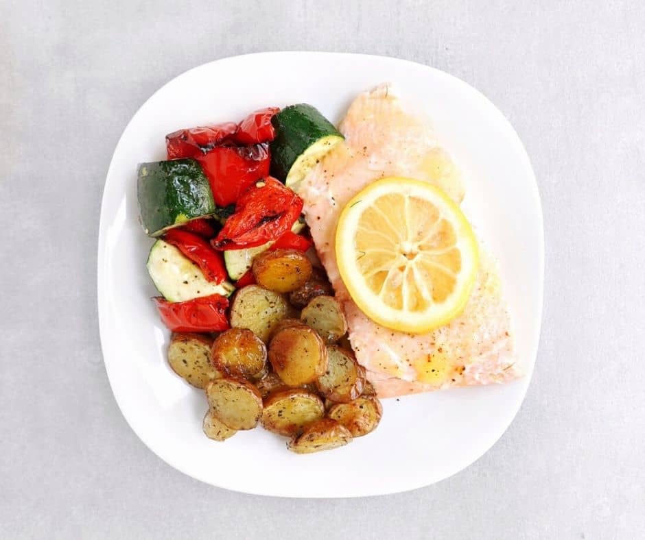 Low FODMAP salmon with roasted lemon, roasted vegetables, and potatoes on plate