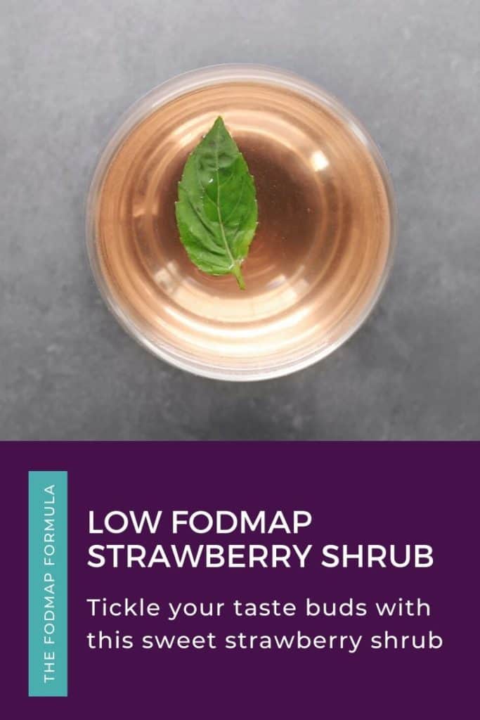 Low FODMAP strawberry shrub in wine glass with fresh basil