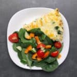 Low FODMAP vegetable frittata with vegetable salad on white plate