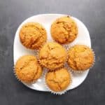Low FODMAP ginger pumpkin muffins piled on white plate