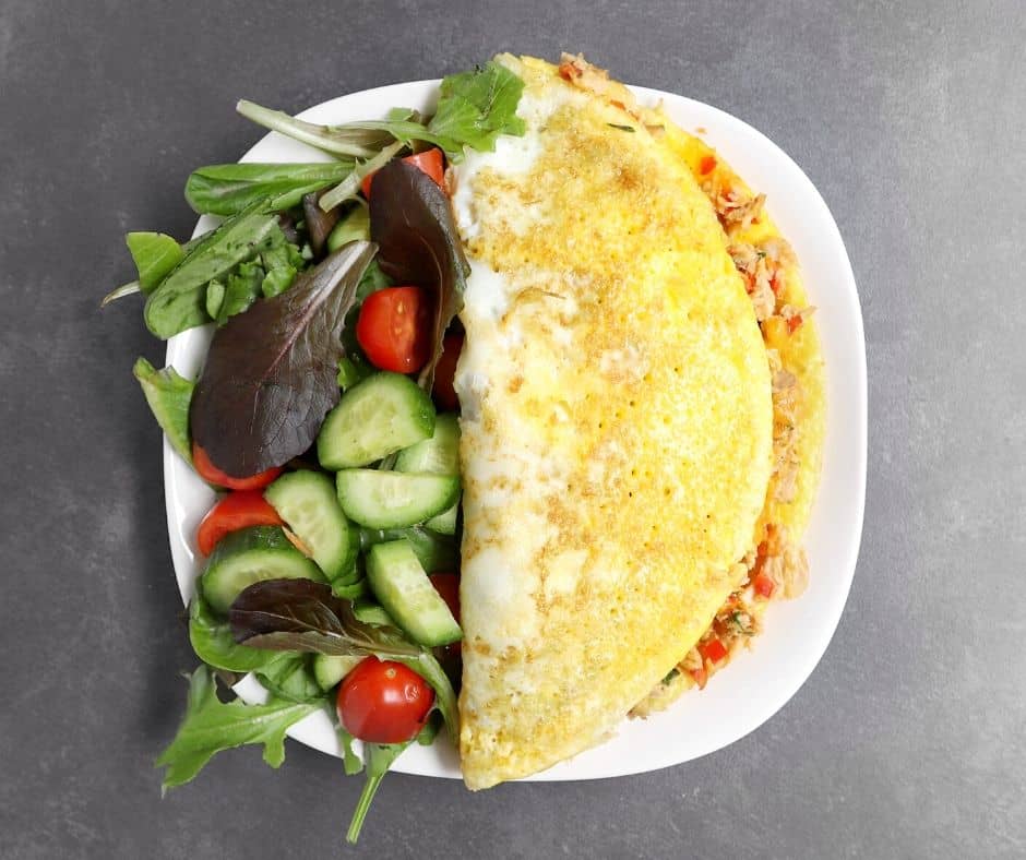 Low FODMAP omelet on white plate with garden salad