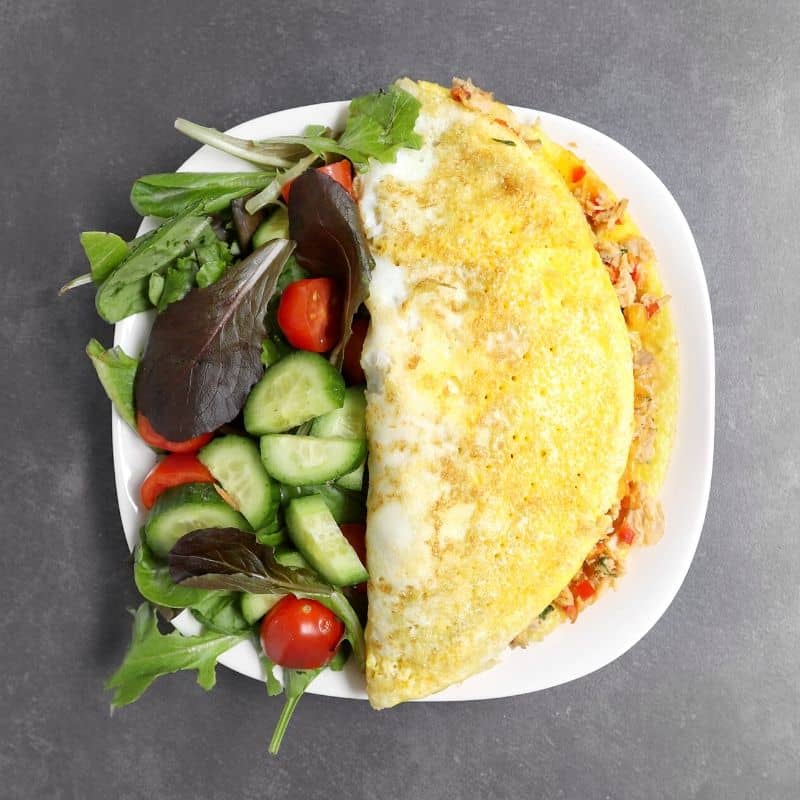 Low FODMAP omelet on white plate with garden salad