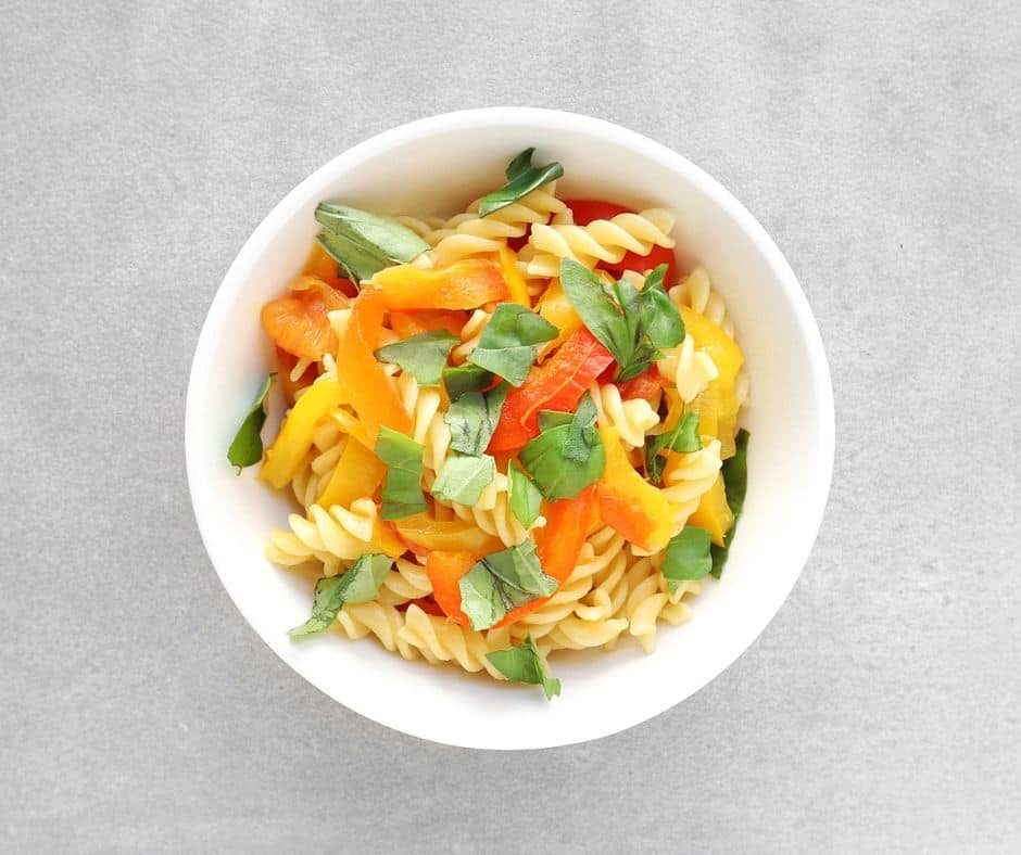 Pasta with roasted red pepper sauce in white bowl