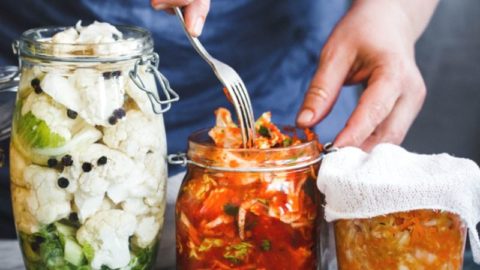 Man packaging fermented food in glass jars