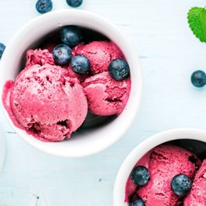 Raspberry ice cream in white bowl