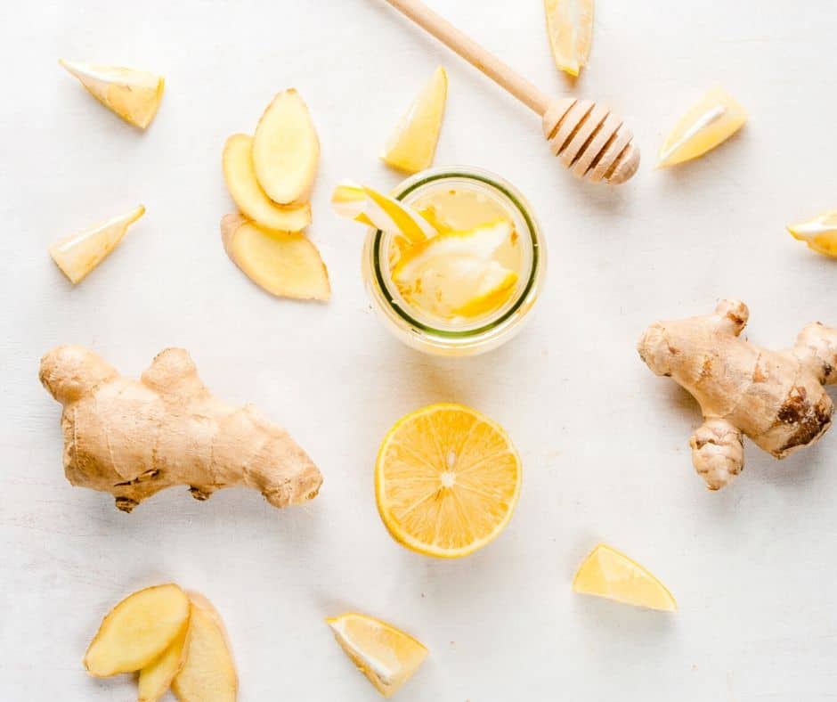 fresh ginger, lemons, and honey laying on a counter