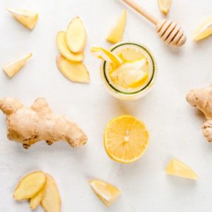 fresh ginger, lemons, and honey laying on a counter